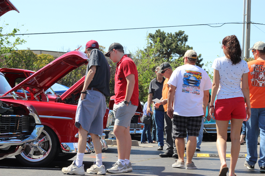 Crowds of people enjoy looking at vintage and custom cars at the 2018 Miracle Car Show held at Tinker Federal Credit Union's Operations Center.