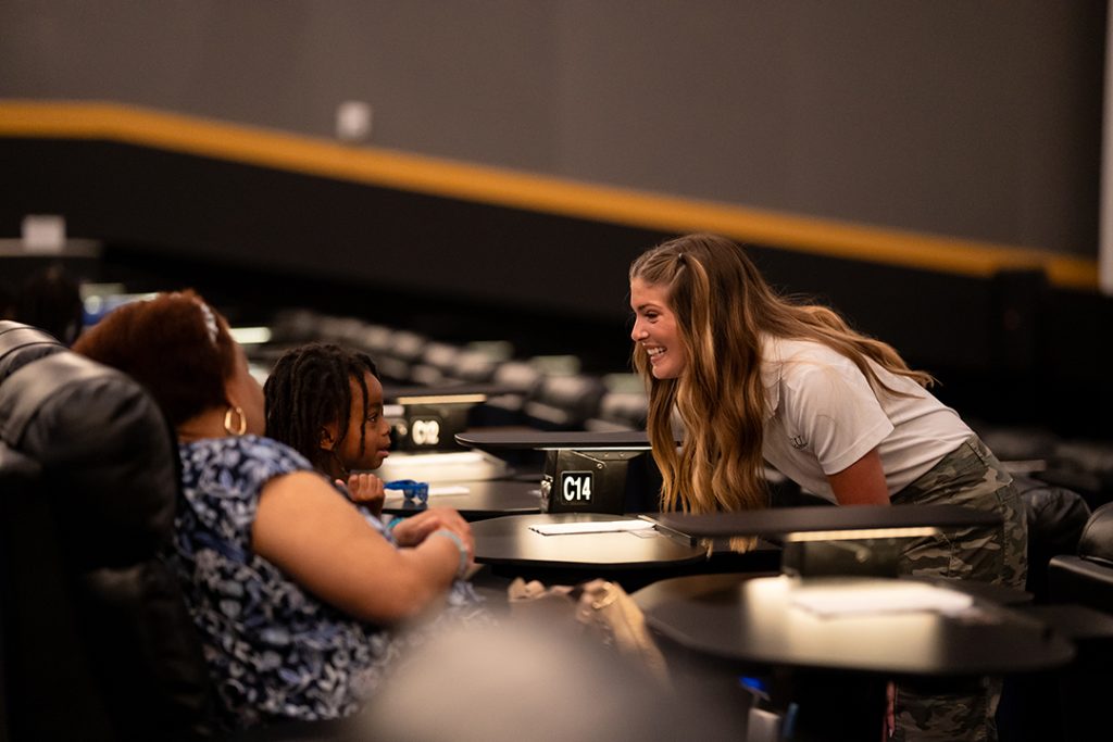 Woman talking to a member at the movie event.