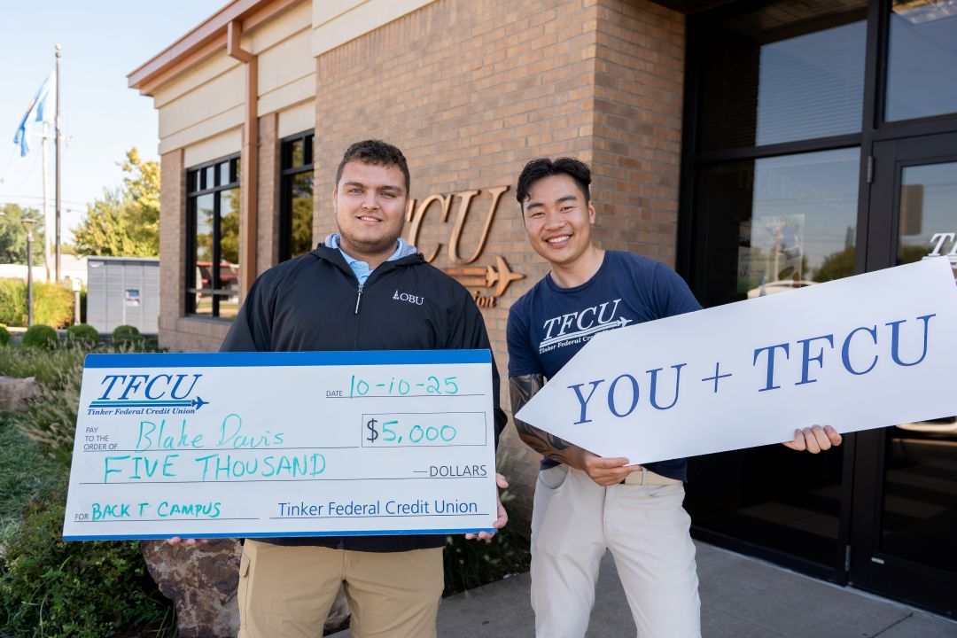 A back to campus winner holding a large check with a TFCU employee holding a sign.