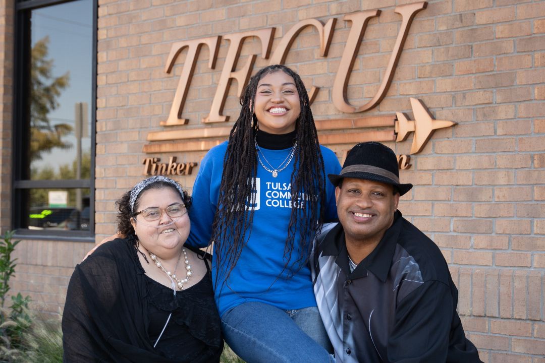 Two family members holding up a back to campus winner student.