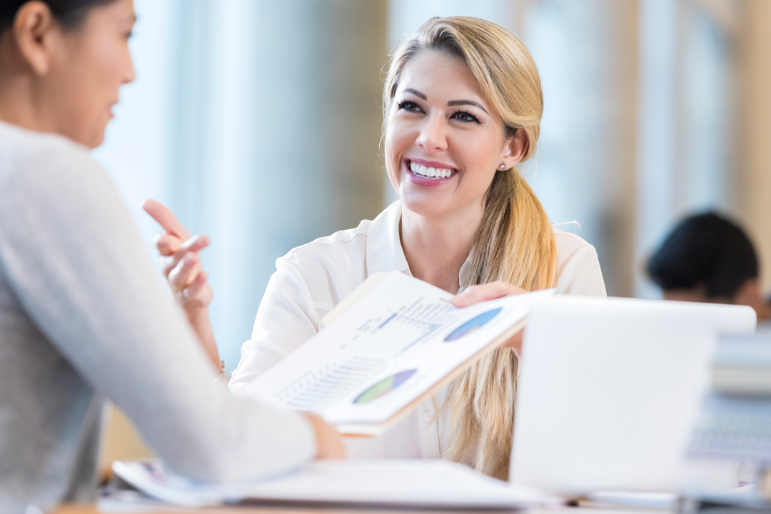 Smiling women discussing year-end financial results