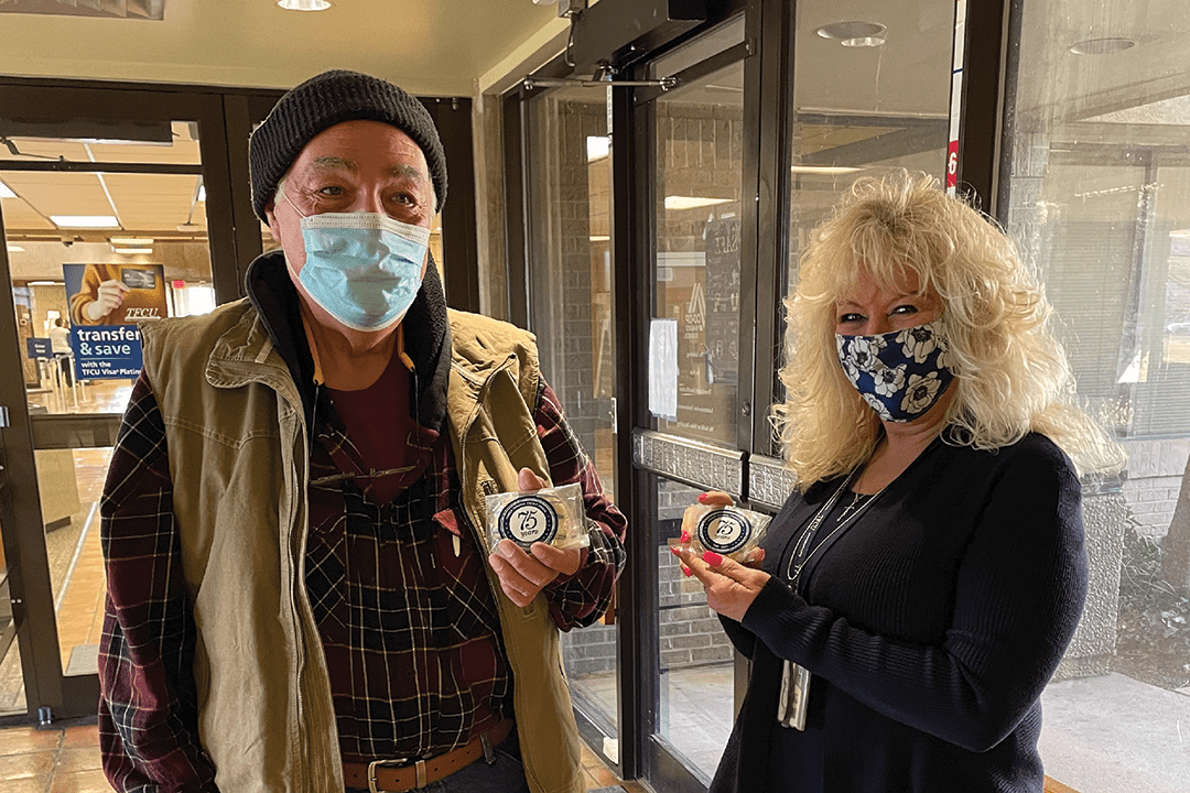 Two people holding up cookies