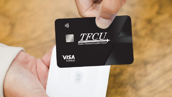 TFCU Visa Business credit card being tapped against a contactless payment terminal.