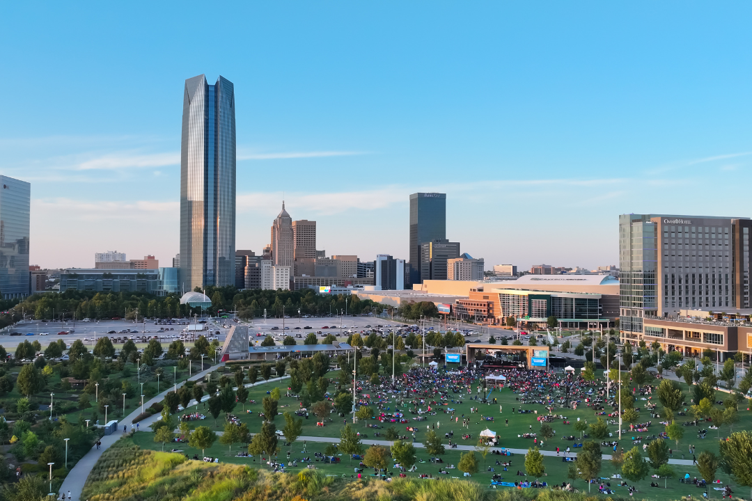 Bird's eye view of a Scissortail Park concert with the Oklahoma City skyline in the background.