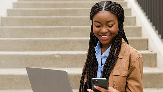 Young woman looking down at the mobile phone in her hand