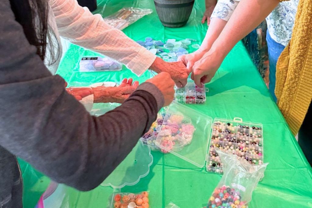 People reaching for beads