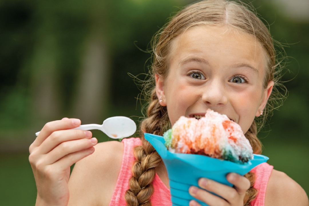 Young girl eating a snowcone