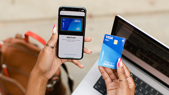 Close up of someone holding a mobile device and a moneyplus card