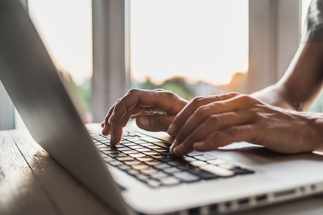 Close up of hands typing on a laptop