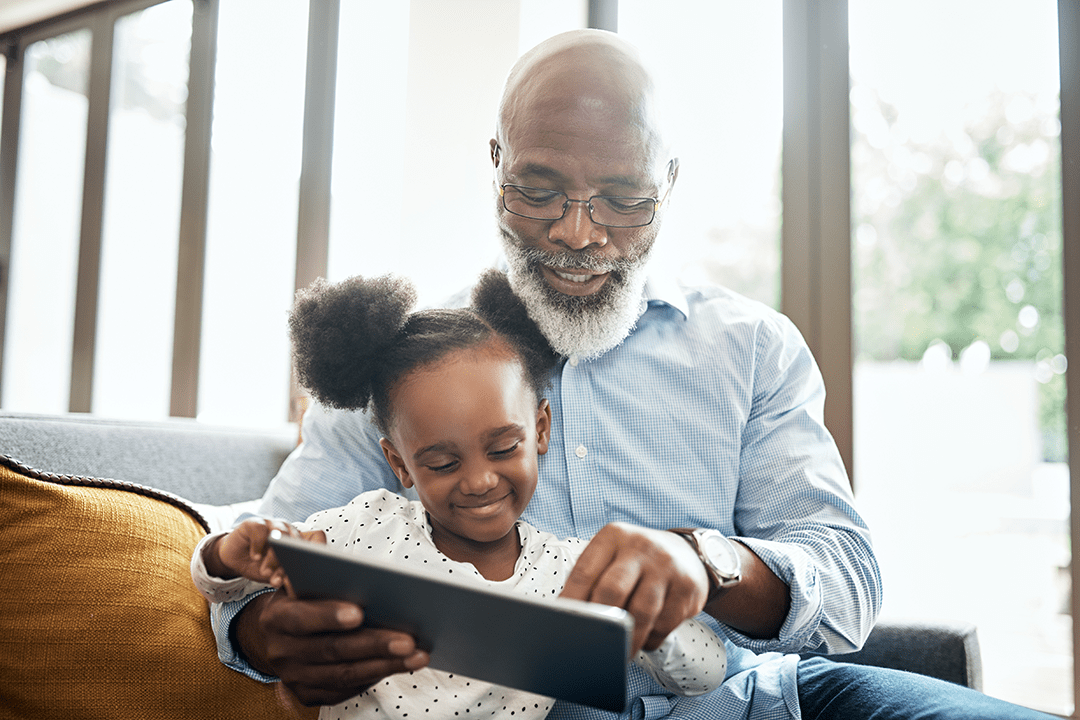Older man and his grandchild on a tablet