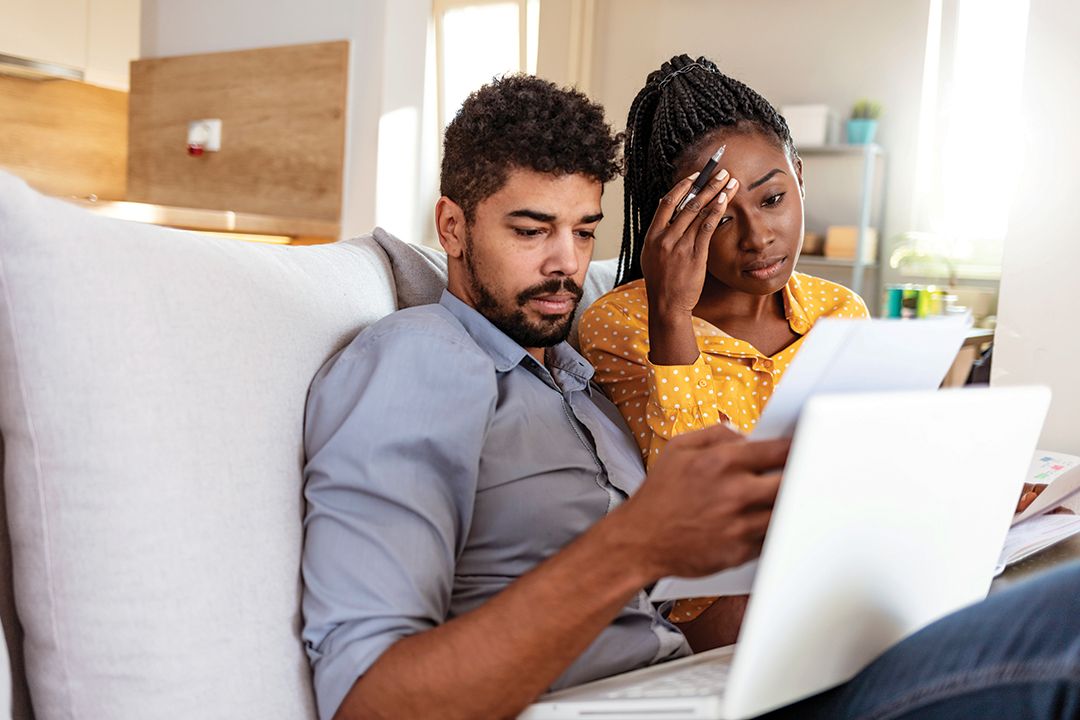 A couple on the couch with a laptop and looking at pictures