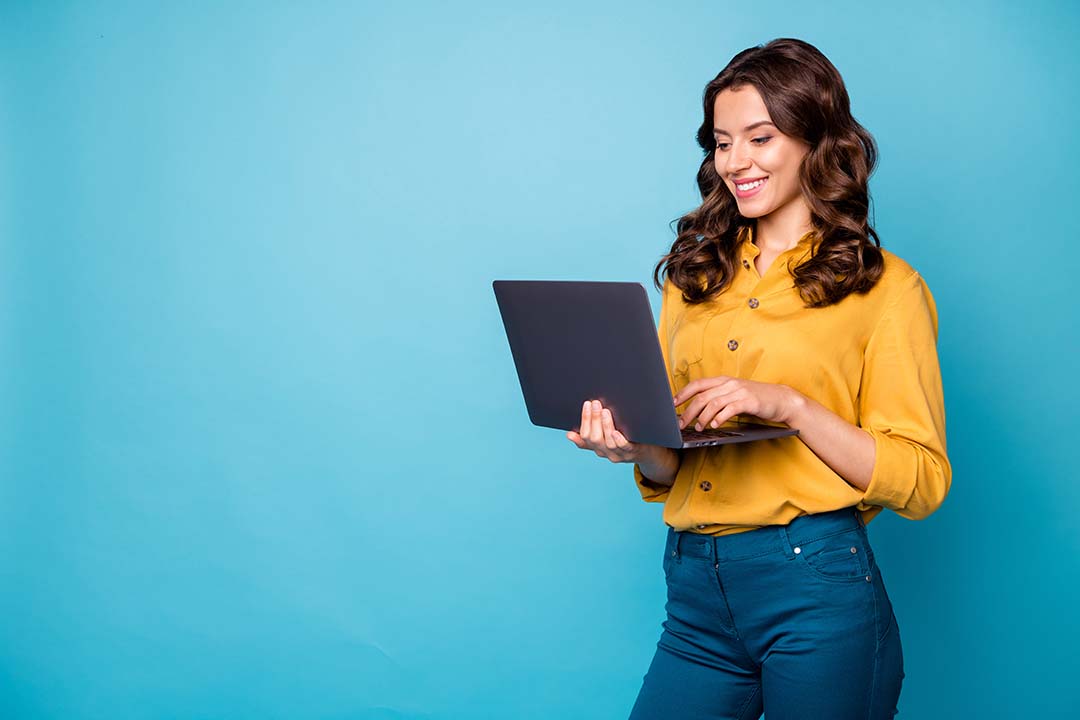 Woman holding a laptop while standing