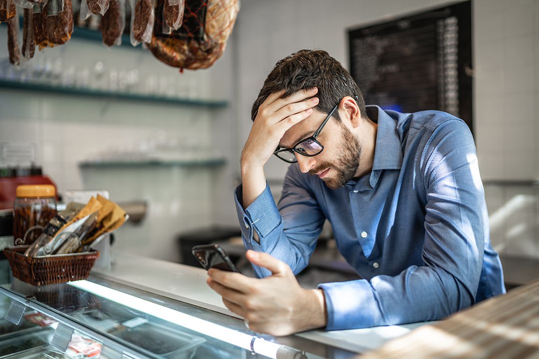 A frustrated man looking at his mobile device