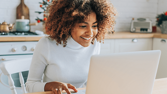 Young woman on her laptop in the kitchen