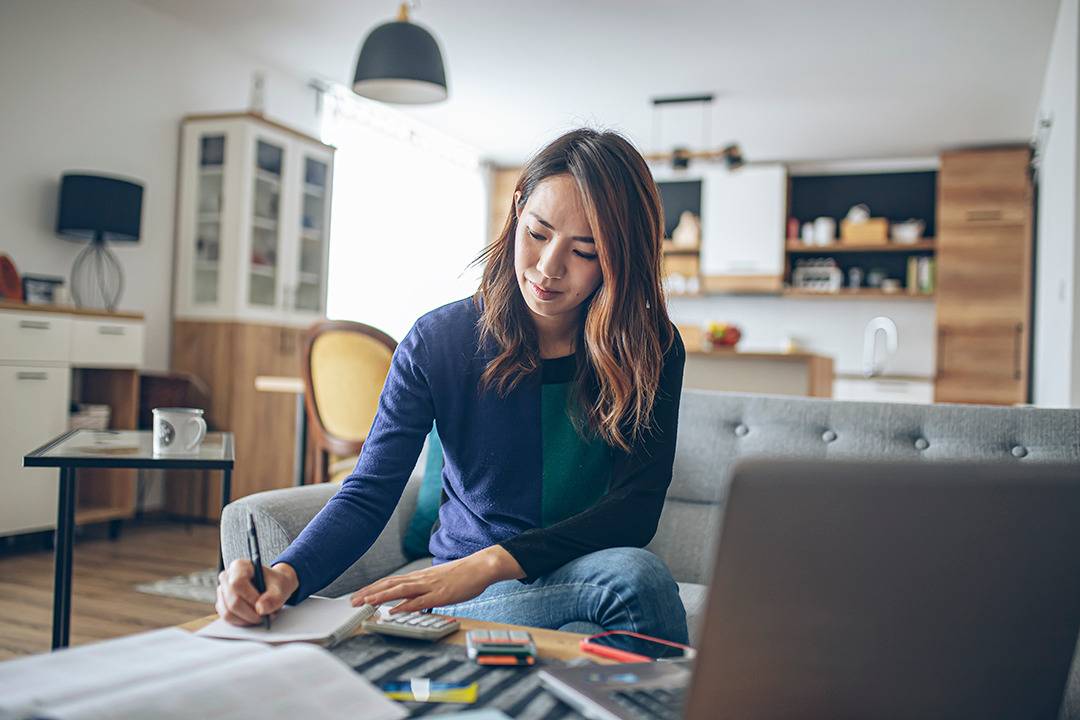 Young woman sitting in the living room and writing