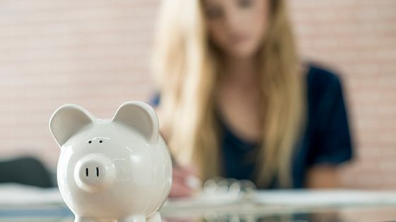 Piggy bank with a student in the background