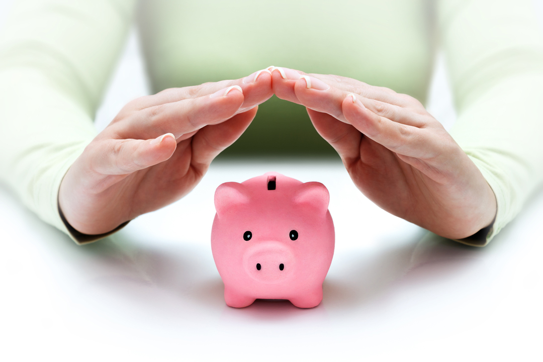 Woman in green top with her hands steepled over a pink piggy bank.