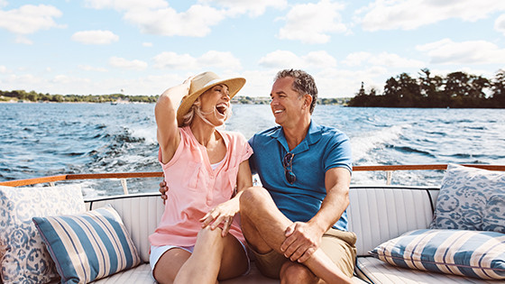 Man and woman sitting in boat laughing and enjoying life at the lake.