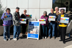 Group of older people holding painted canvases