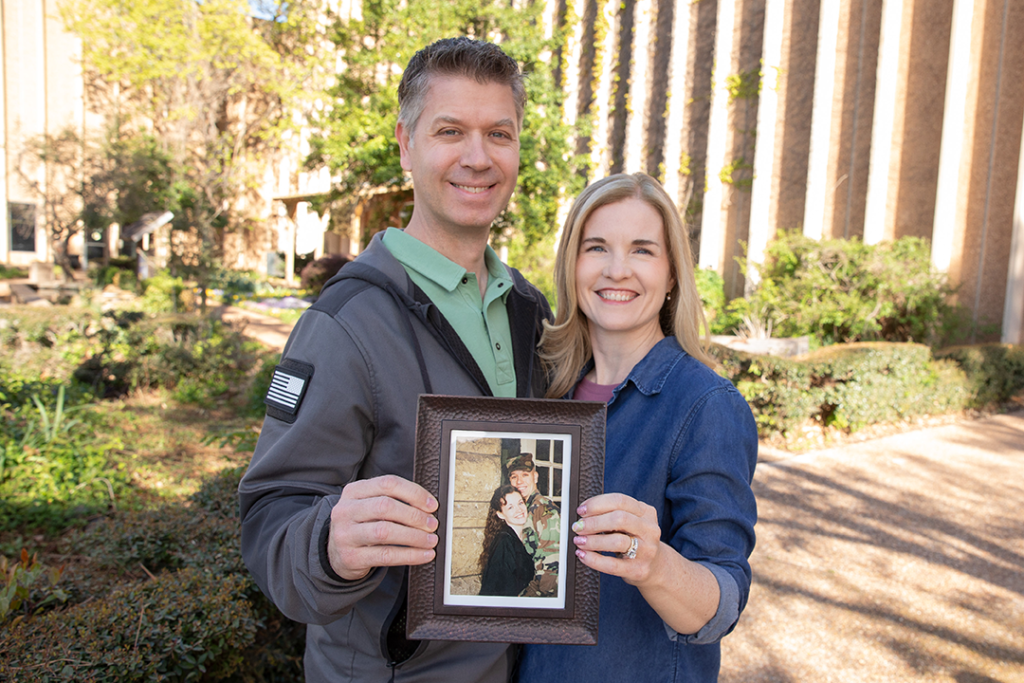 Close up of a husband and wife holding up a picture frame