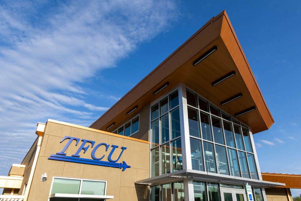 New Norman TFCU branch entrance with blue sky background.