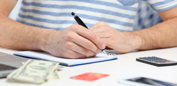 closeup of male writing out check