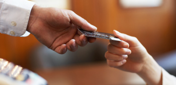 Hands exchanging a credit card for a purchase