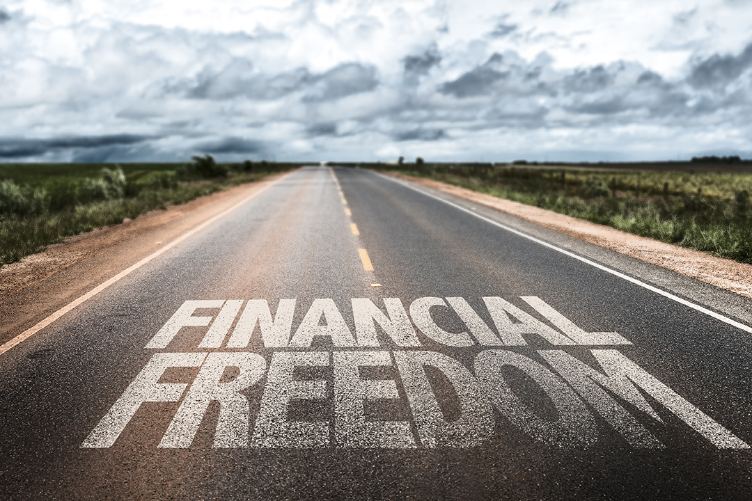 Highway with the words Financial Freedom spelled in bold letters on the pavement