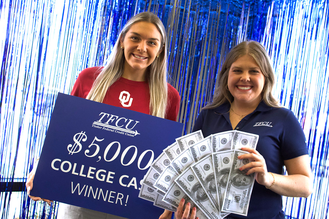 Young woman who is a student is holding up a sign that says $5,000 college cash winner, with a TFCU employee holding up a stack of cash