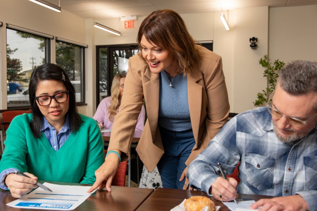 A TFCU financial educator showing a woman something on paper.