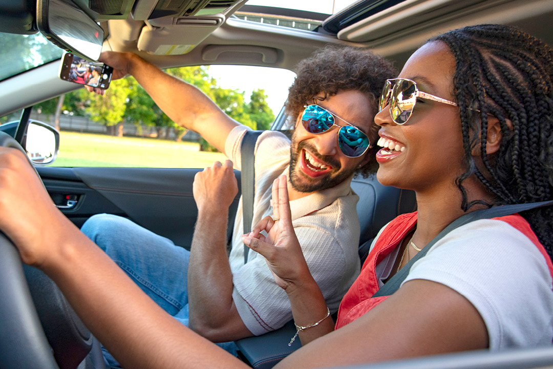 A man and woman taking a selfie in a car