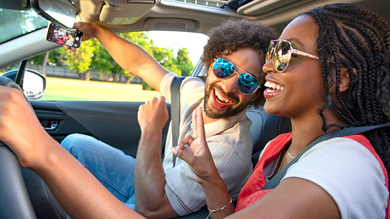 A man and woman taking a selfie in the car