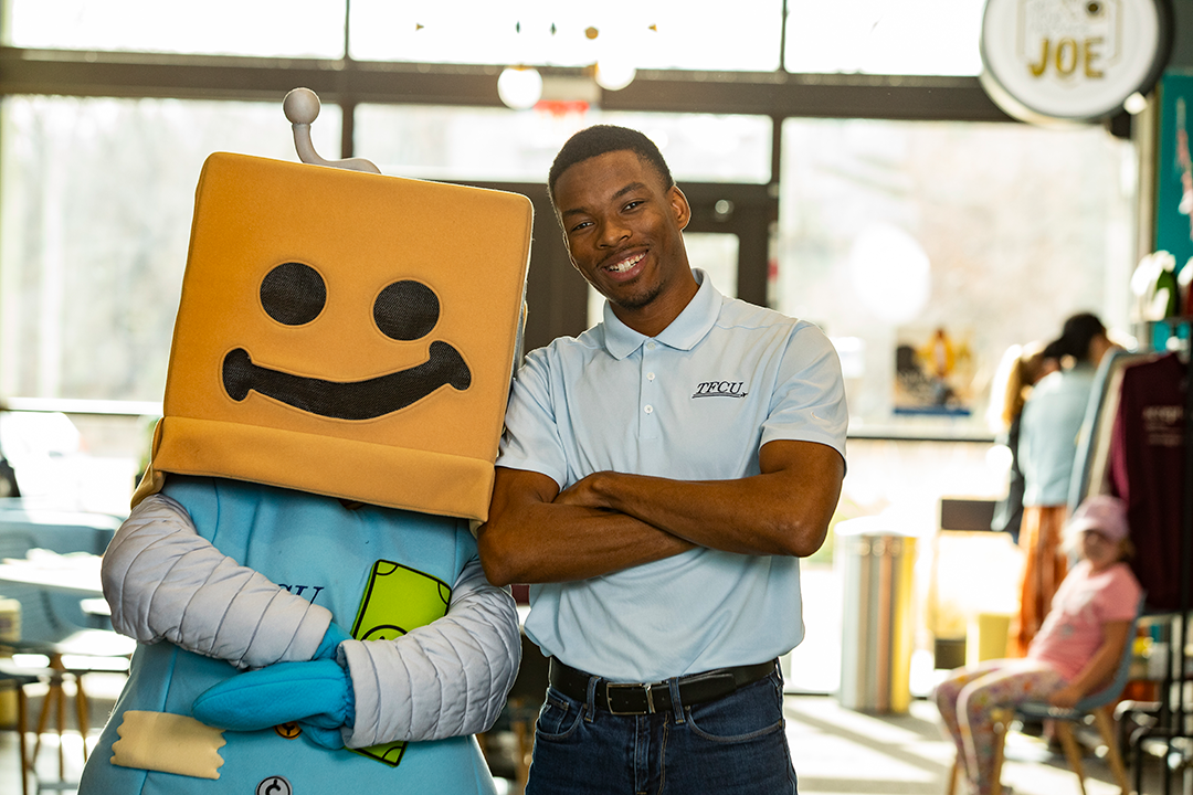 A TFCU employee standing with Save-A-Tron.