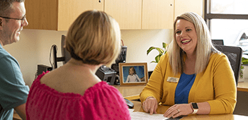 Employee talking to members in an office