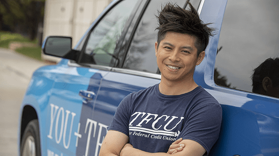 TFCU Employee standing next to a TFCU Corporate Car.