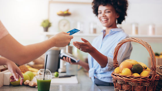 Member making purchase at smoothie bar with thier TFCU Visa Classic credit card.