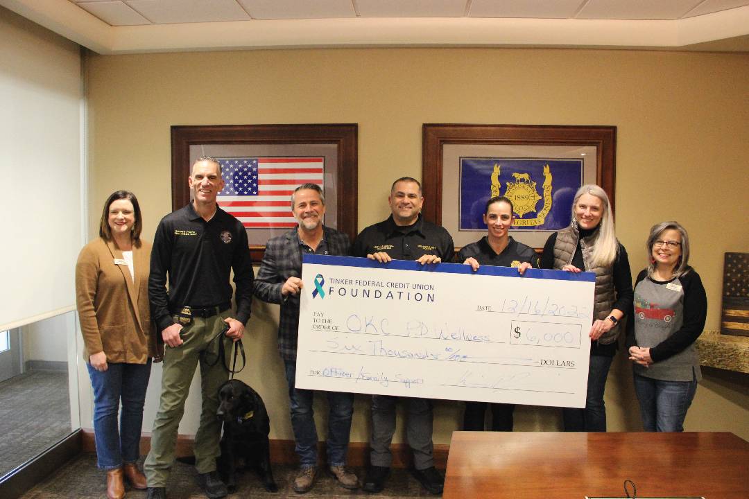 Group of people standing together and holding a big check