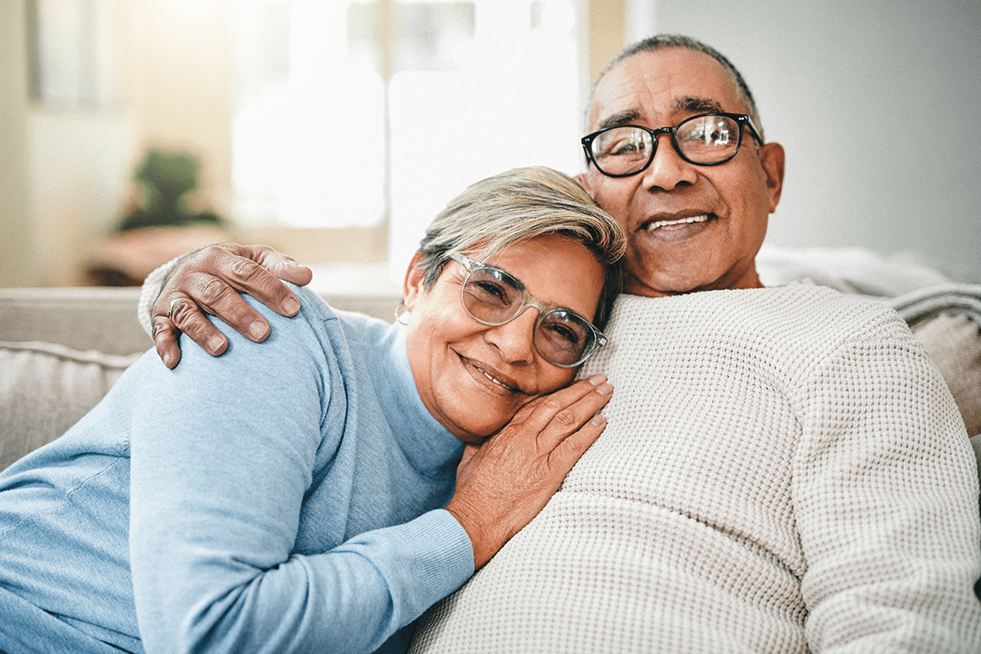 An older couple sitting on the couch