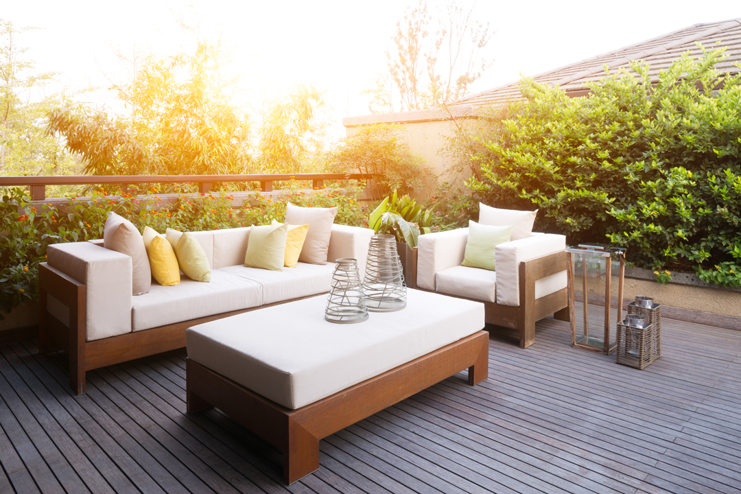 Sunny patio seating area with couch, chair and table