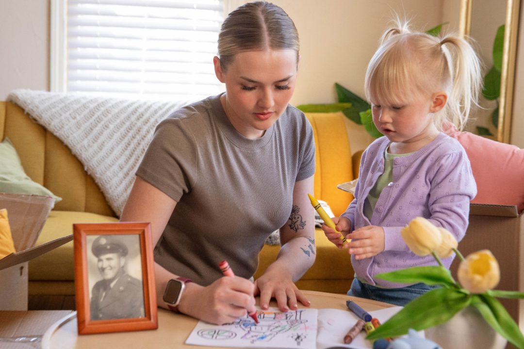 A mom and daughter coloring in a booklet