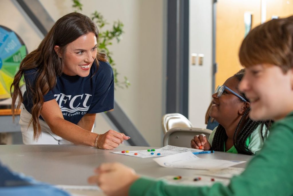 A TFCU financial educator works with kids