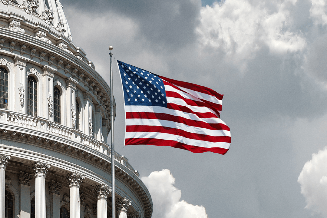 American flag with a building structure in the back