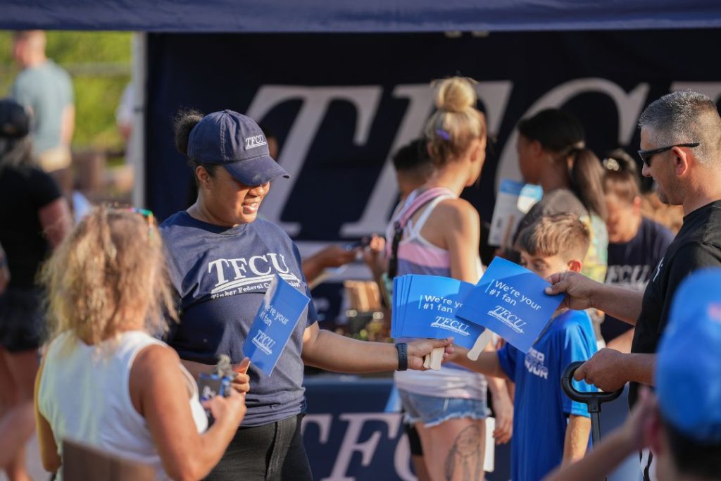 A TFCU employee hands out flags