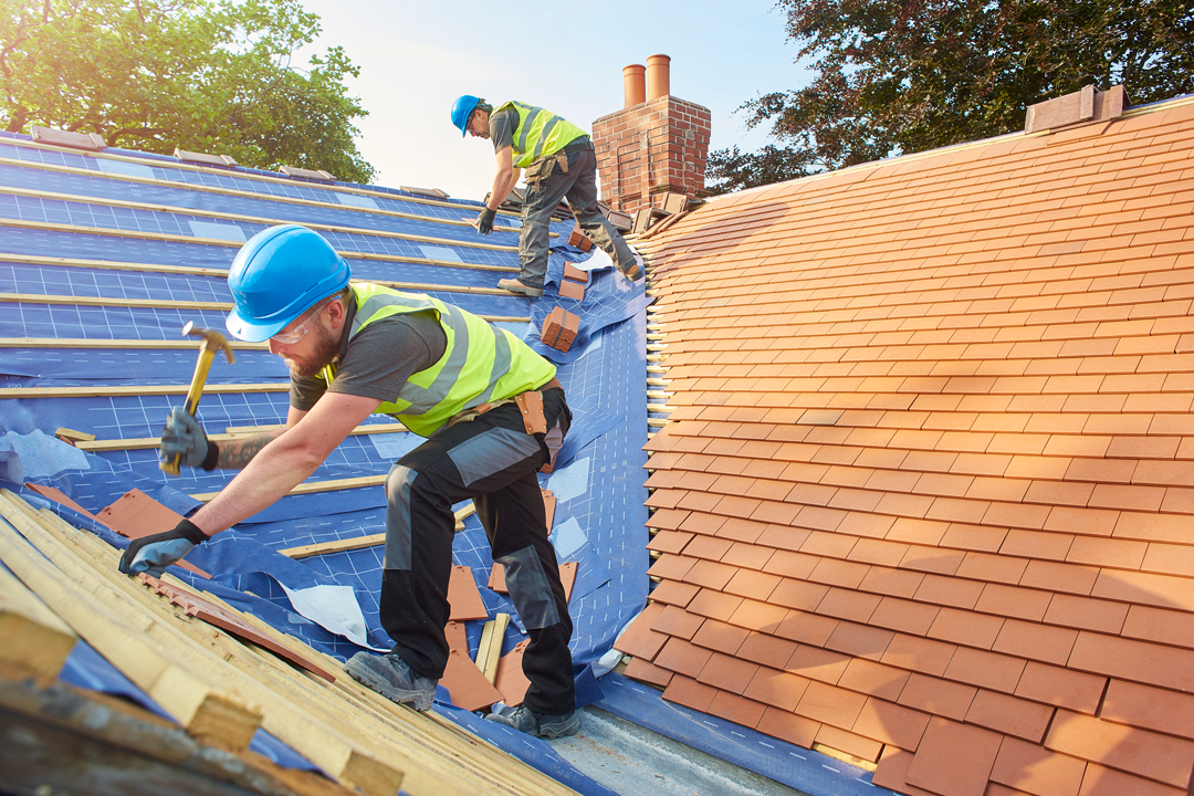 Two men shingling roof.