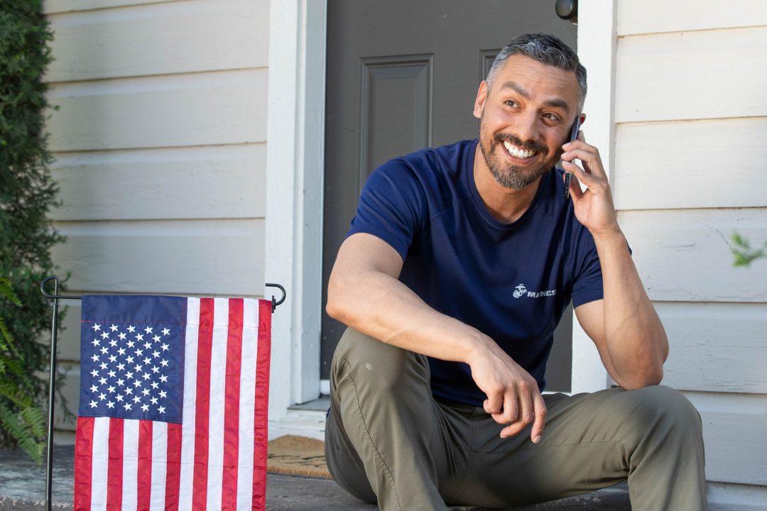 A man sitting on the porch on his mobile phone