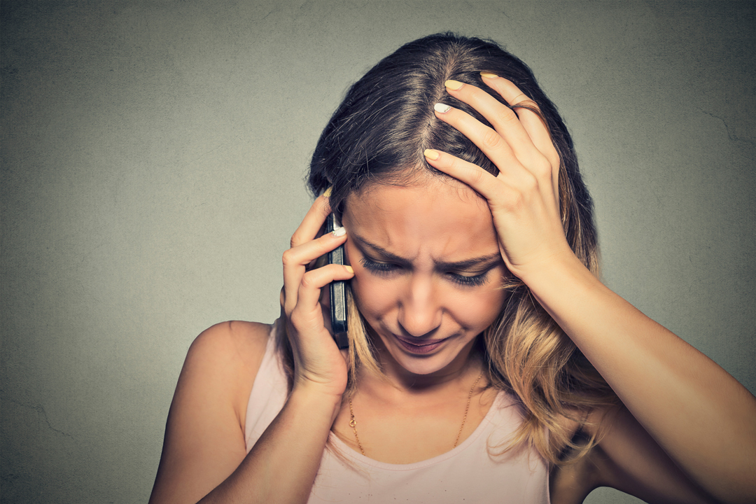 Young woman looking down while talking on a mobile phone